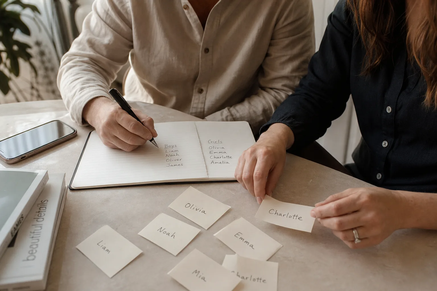 Parents writing and sorting baby names by hand in a calm home setting